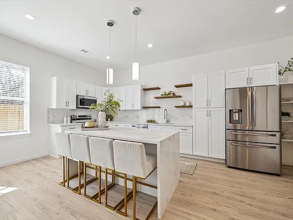 Kitchen island with counter stools and a stainless refrigerator, Bianco Lane, Houston TX 77091