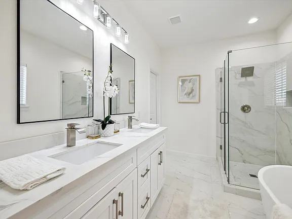 Primary bathroom with a double vanity and a glass shower enclosure, Bianco Lane, Houston TX 77091