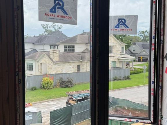 Royal Windoor casement windows installed in a new build, factory labels visible on the glass
