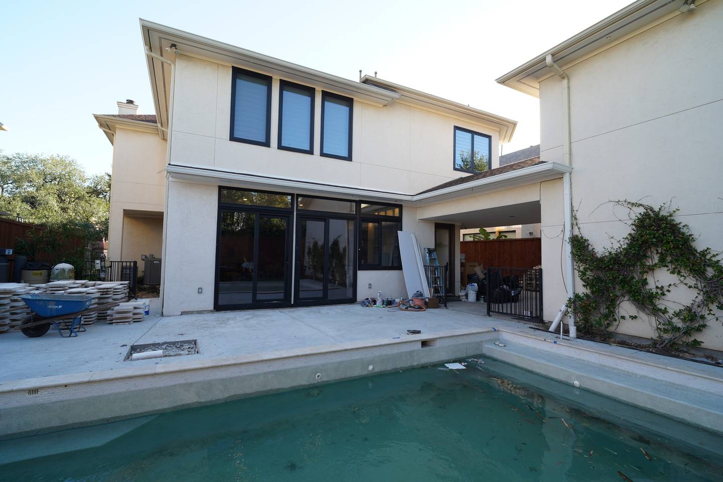 Rear of a home on Maroneal St in Houston 77025 with dark-framed windows and sliding doors by Royal Windoor across the pool