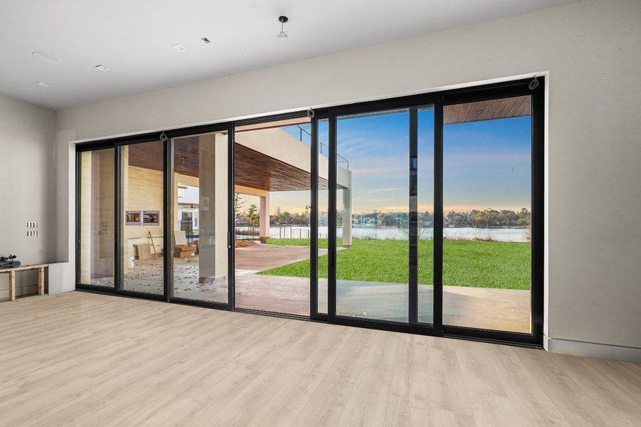 Multi-panel sliding doors opening to the lawn and the water, The Woodlands TX 77380
